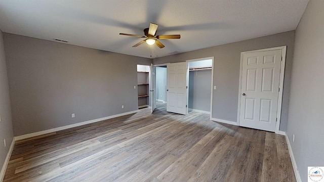 607 E Benton St, Windsor, MO 65360 - unfurnished bedroom featuring wood finished floors, visible vents, and baseboards