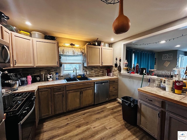 106 W Fairview St, Clinton, MO 64735 - kitchen with stainless steel appliances, a sink, tile countertops, wood finished floors, and tasteful backsplash