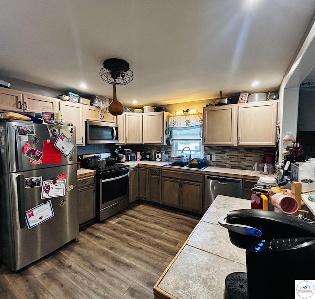 106 W Fairview St, Clinton, MO 64735 - kitchen with stainless steel appliances, a sink, light countertops, backsplash, and dark wood finished floors