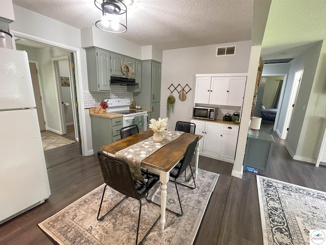 22756 Hickory Chapel Ave, Lincoln, MO 65338 - dining space with a textured ceiling, dark wood finished floors, and baseboards