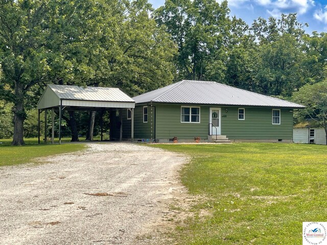 22756 Hickory Chapel Ave, Lincoln, MO 65338 - view of front facade with a detached carport, driveway, metal roof, a front lawn, and entry steps