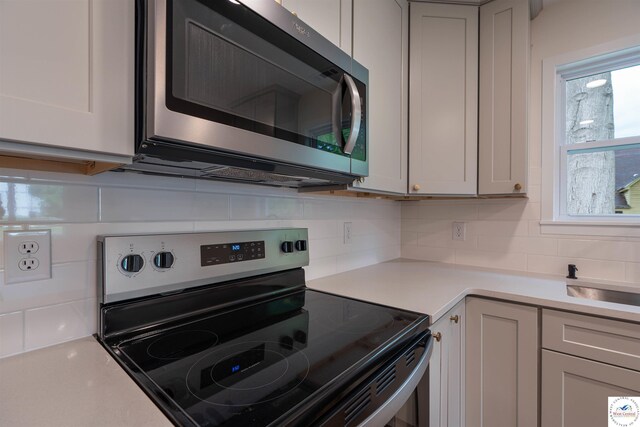 1504 E 7th St, Sedalia, MO 65301 - kitchen with stainless steel appliances, tasteful backsplash, and light countertops