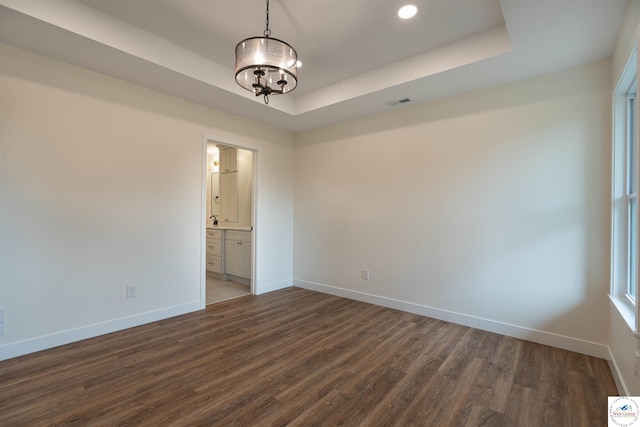 1504 E 7th St, Sedalia, MO 65301 - empty room with a raised ceiling, dark wood finished floors, recessed lighting, and a chandelier