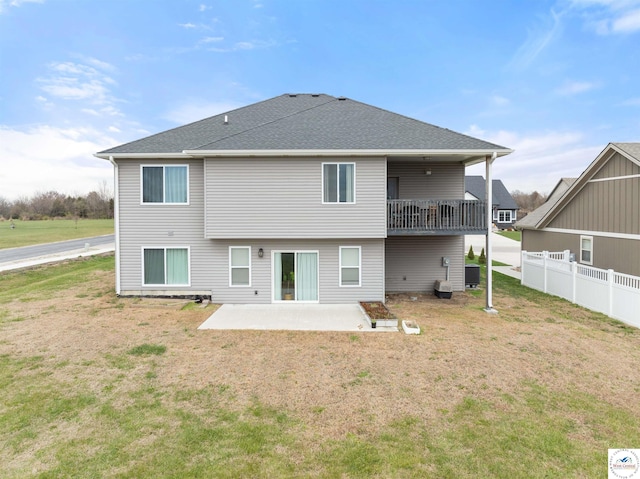 rear view of house with a patio, fence, a balcony, and a lawn