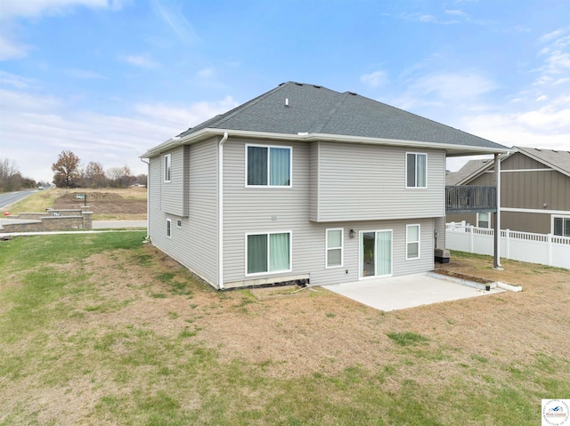 back of property featuring a lawn, fence, a patio area, and a shingled roof