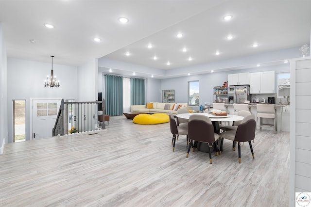dining space featuring light wood-type flooring, recessed lighting, and a notable chandelier