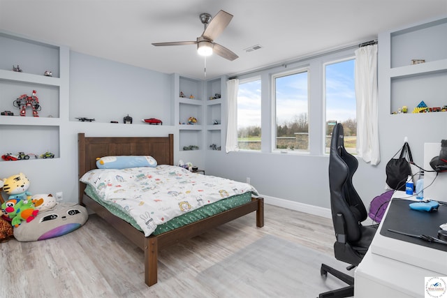 bedroom featuring a ceiling fan, visible vents, wood finished floors, and baseboards