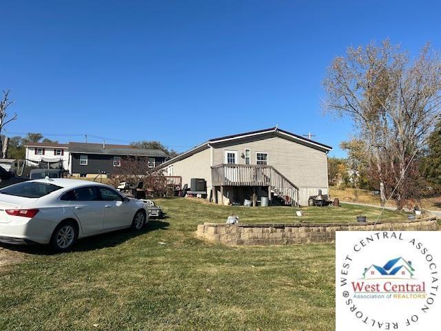 214 SE State St, Milan, MO 63556 - view of side of property featuring a lawn, a deck, and stairway
