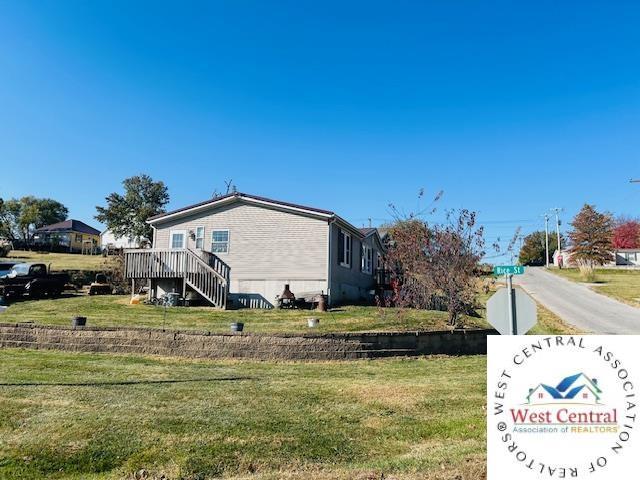 214 SE State St, Milan, MO 63556 - view of side of property with stairway, a deck, and a yard