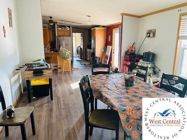 214 SE State St, Milan, MO 63556 - dining area with a wealth of natural light, light wood-style floors, crown molding, and a ceiling fan