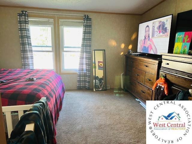 214 SE State St, Milan, MO 63556 - carpeted bedroom featuring multiple windows and crown molding