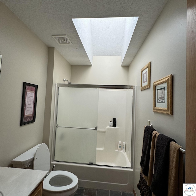 30342 Sassafras Dr, Warsaw, MO 65355 - full bath with a textured ceiling, bath / shower combo with glass door, toilet, vanity, and a skylight