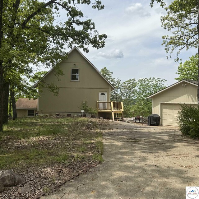 30342 Sassafras Dr, Warsaw, MO 65355 - view of side of property featuring a deck, a garage, and driveway