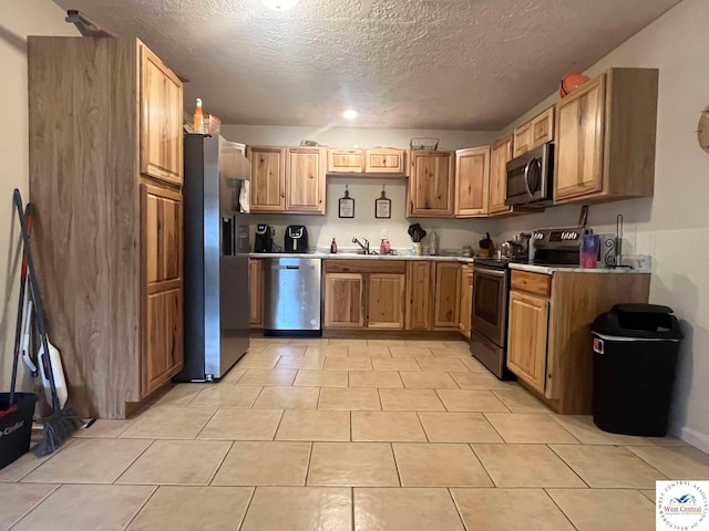100 NW 4343 P Ln, Clinton, MO 64735 - kitchen with light tile patterned floors, stainless steel appliances, light countertops, a sink, and a textured ceiling
