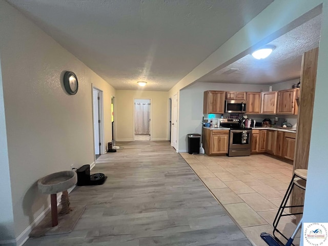 100 NW 4343 P Ln, Clinton, MO 64735 - kitchen featuring baseboards, a textured ceiling, appliances with stainless steel finishes, and light countertops
