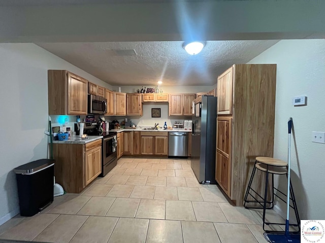 100 NW 4343 P Ln, Clinton, MO 64735 - kitchen featuring brown cabinetry, a textured ceiling, appliances with stainless steel finishes, and a sink