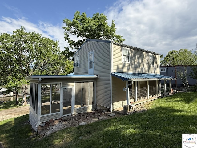 rear view of property with a sunroom and a yard