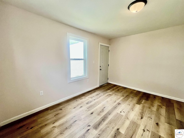 unfurnished room with baseboards and wood finished floors
