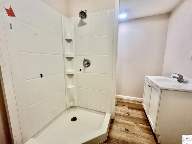 full bathroom featuring baseboards, vanity, wood finished floors, and a shower stall