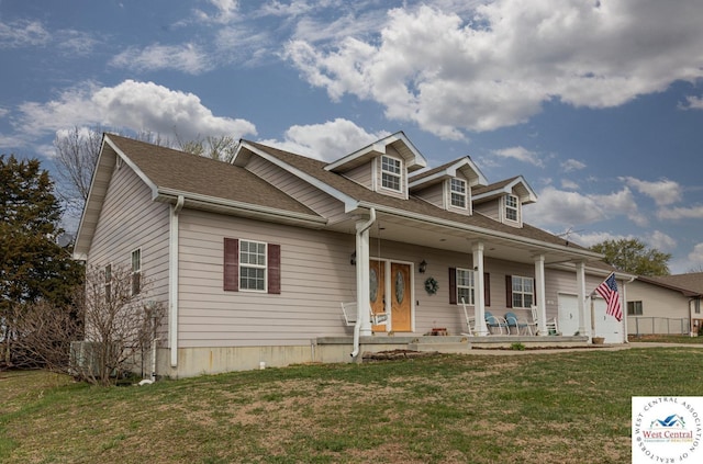 cape cod house with a front lawn, covered porch, and roof with shingles