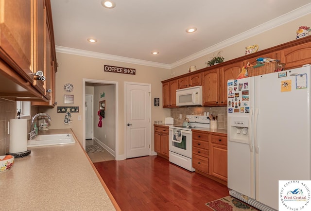 kitchen with a sink, light countertops, ornamental molding, white appliances, and backsplash