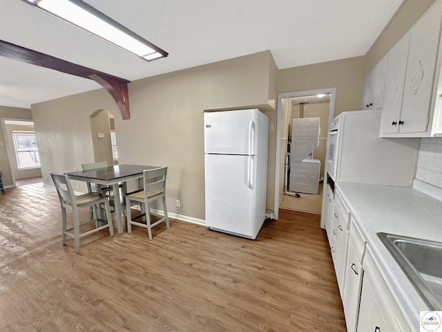 26684 Waterview Dr, Warsaw, MO 65355 - kitchen featuring white appliances, arched walkways, white cabinets, and light wood finished floors