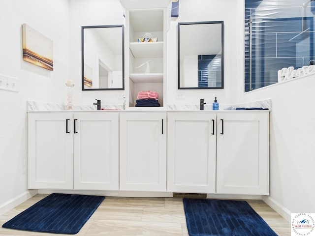 100 Mayerling Dr, Laurie, MO 65037 - bathroom featuring baseboards, double vanity, and visible vents