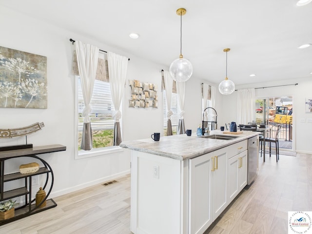 100 Mayerling Dr, Laurie, MO 65037 - kitchen featuring hanging light fixtures, a sink, light wood-style flooring, stainless steel dishwasher, and visible vents