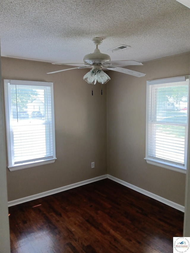 219 S 6th St, Clinton, MO 64735 - spare room with plenty of natural light, dark wood finished floors, ceiling fan, a textured ceiling, and baseboards