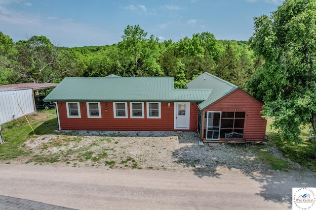 28848 Paradise Dr, Warsaw, MO 65355 - view of front of property featuring a view of trees, a sunroom, and metal roof