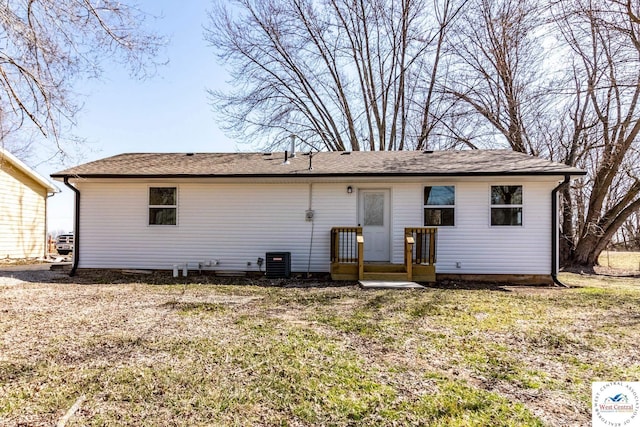 back of property featuring a yard, central AC, and a shingled roof