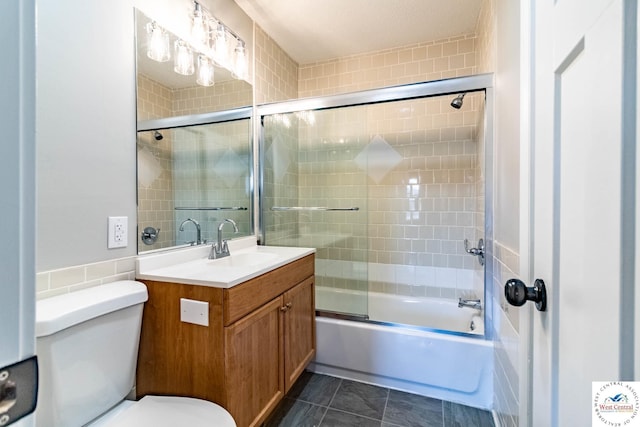full bath featuring bath / shower combo with glass door, toilet, and vanity