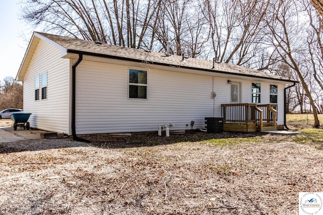rear view of house with roof with shingles