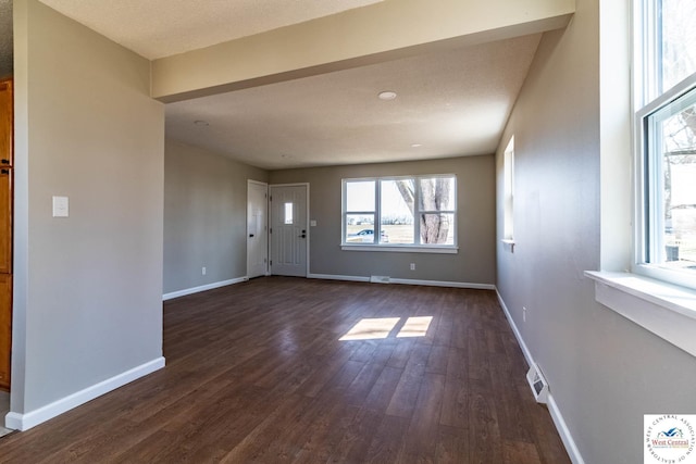 foyer entrance with baseboards, visible vents, and dark wood-type flooring
