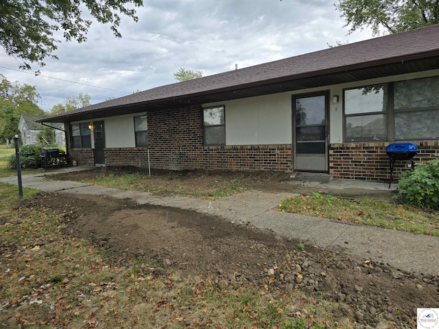 206 N Ohio St, Chilhowee, MO 64733 - view of home's exterior featuring roof with shingles and brick siding