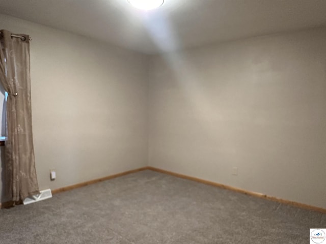 carpeted empty room featuring visible vents and baseboards