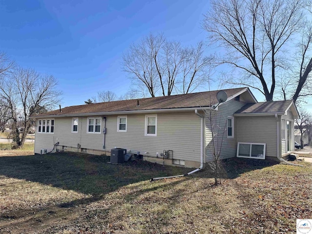 back of house featuring a lawn and central AC unit