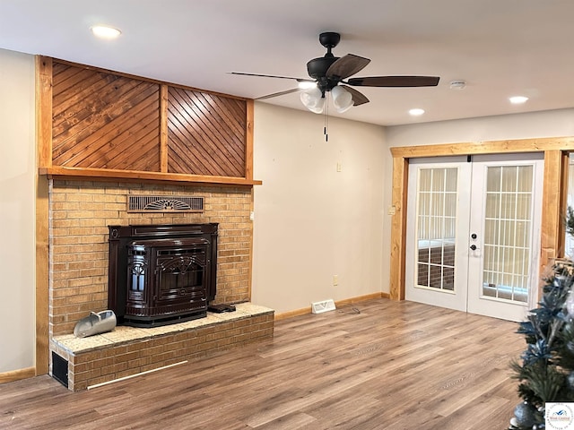 unfurnished living room featuring baseboards, wood finished floors, ceiling fan, and french doors
