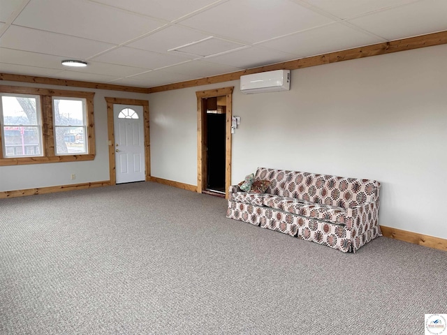 interior space featuring baseboards, a wall unit AC, carpet floors, and a drop ceiling