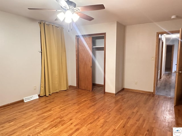 interior space featuring ceiling fan, visible vents, light wood-type flooring, and baseboards