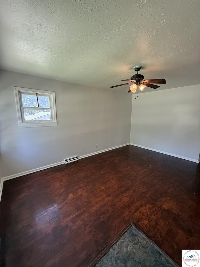 7801 Ozark Rd, Kansas City, MO 64129 - spare room with ceiling fan, a textured ceiling, and dark wood-type flooring