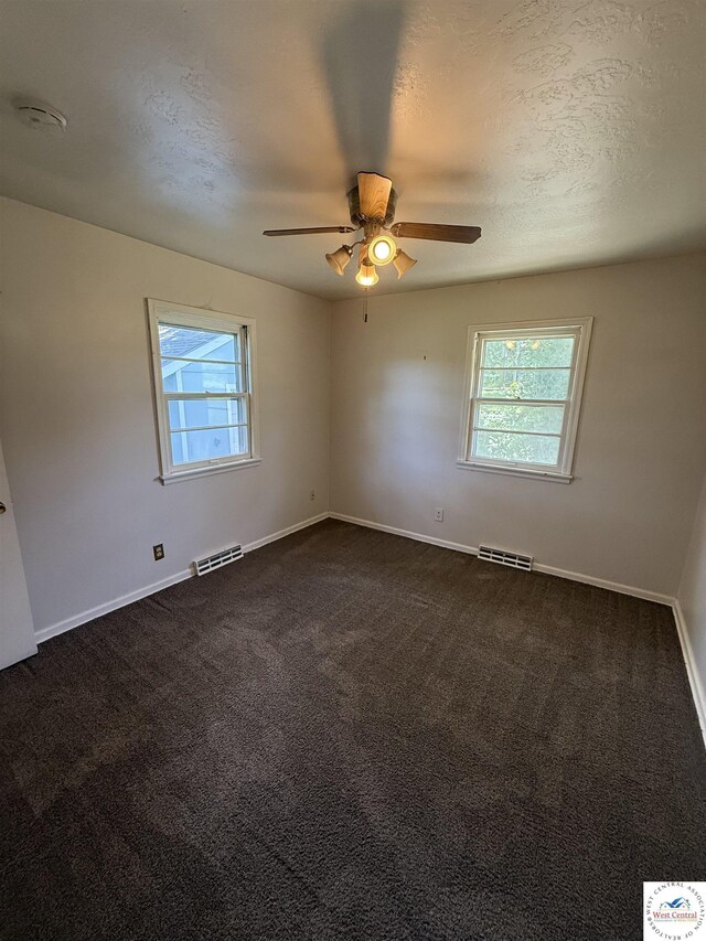 7801 Ozark Rd, Kansas City, MO 64129 - spare room with healthy amount of natural light, ceiling fan, dark colored carpet, and a smoke detector