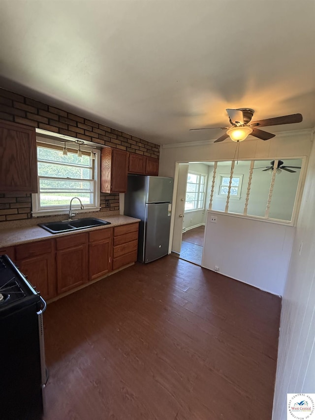 7801 Ozark Rd, Kansas City, MO 64129 - kitchen featuring freestanding refrigerator, gas range oven, dark wood-type flooring, light countertops, and brown cabinets