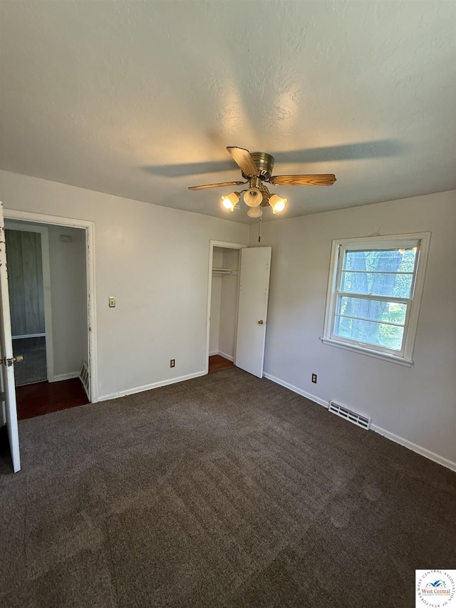 7801 Ozark Rd, Kansas City, MO 64129 - unfurnished bedroom featuring dark colored carpet, a closet, and ceiling fan