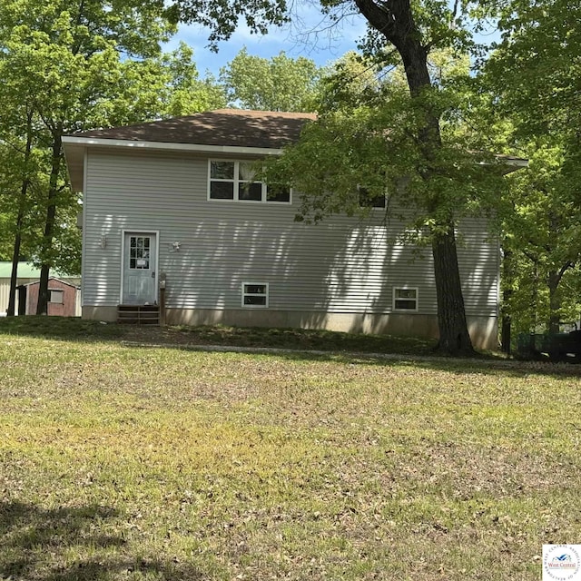 rear view of property featuring a yard and entry steps