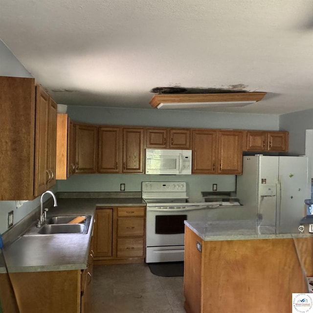 kitchen with brown cabinetry, a sink, and white appliances