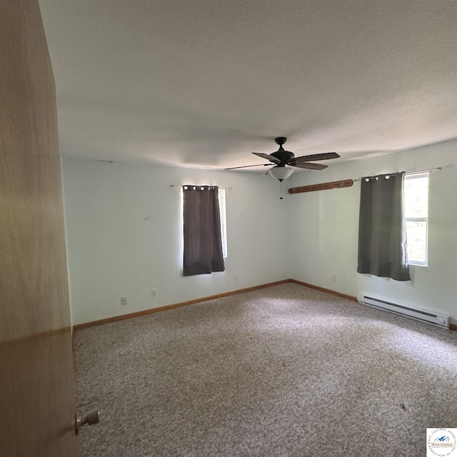 spare room with carpet, baseboards, a ceiling fan, and a baseboard heating unit