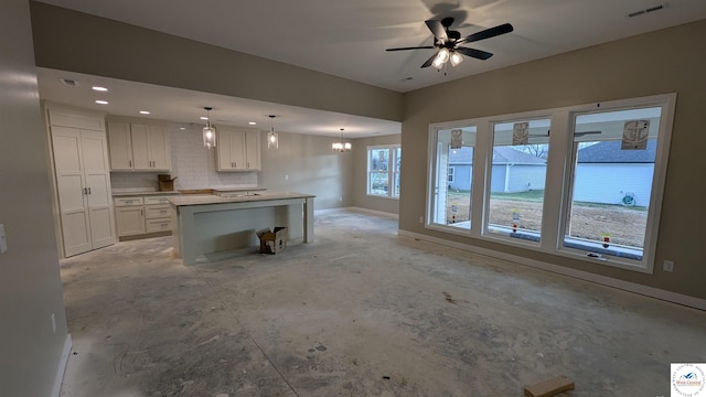 302 E Jamestown Dr, Clinton, MO 64735 - kitchen with white cabinets, tasteful backsplash, a center island, ceiling fan, and decorative light fixtures