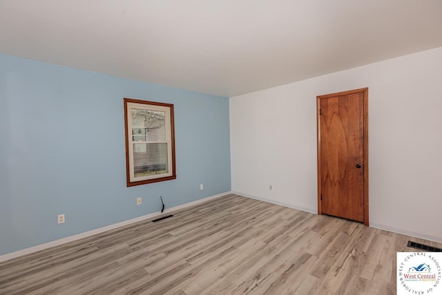 spare room featuring visible vents, baseboards, and light wood-type flooring
