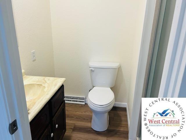 45869 E Hwy, Milan, MO 63556 - bathroom featuring vanity, wood finished floors, and a baseboard heating unit